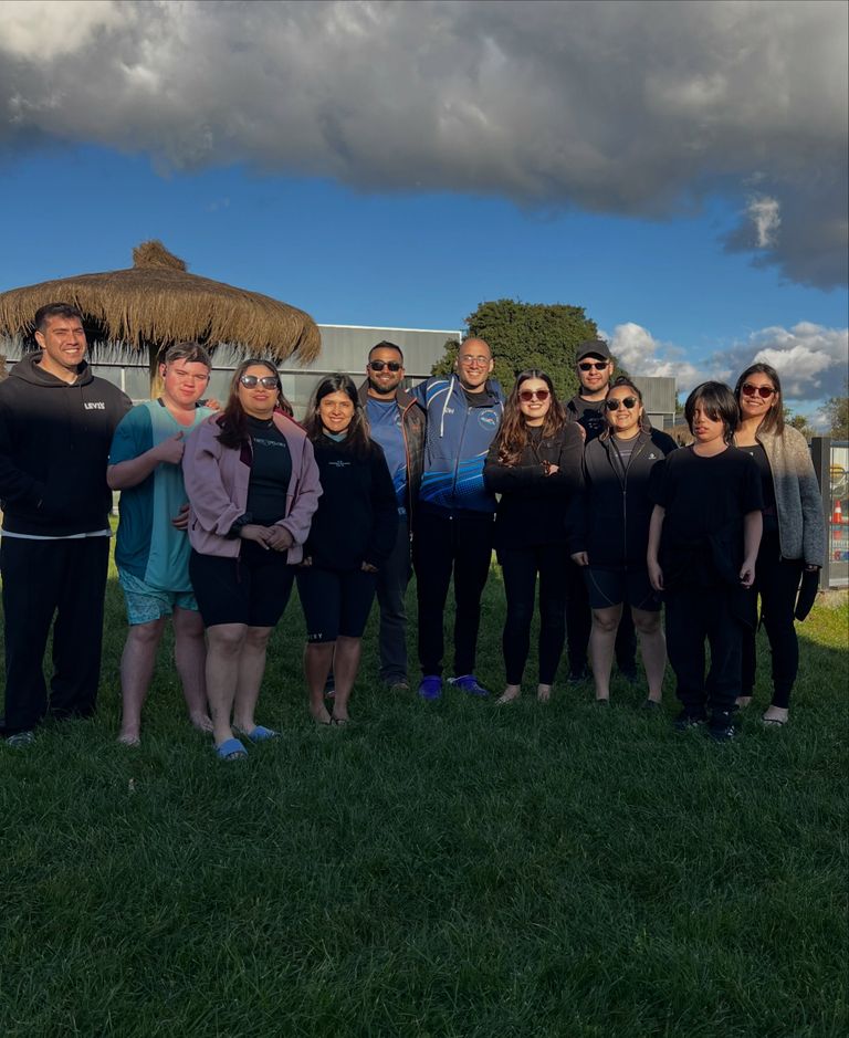 Profesor junto a un grupo de alumnos en el césped de la escuela